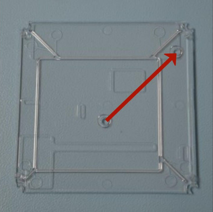 Image showing the translucent bottom part of the case, with two round notches forming a line pointing towards the top right corner